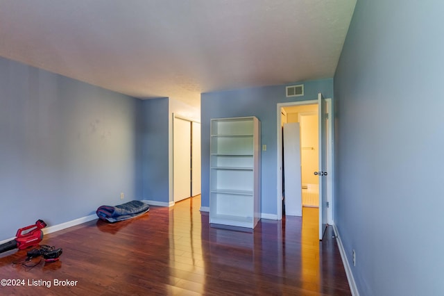 unfurnished bedroom featuring dark hardwood / wood-style floors and a closet