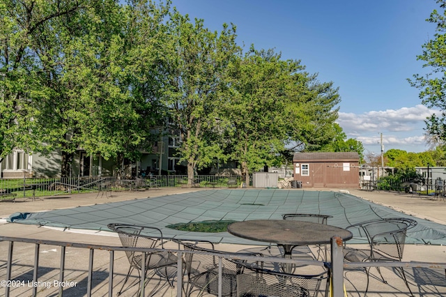 view of pool featuring a storage unit and a patio