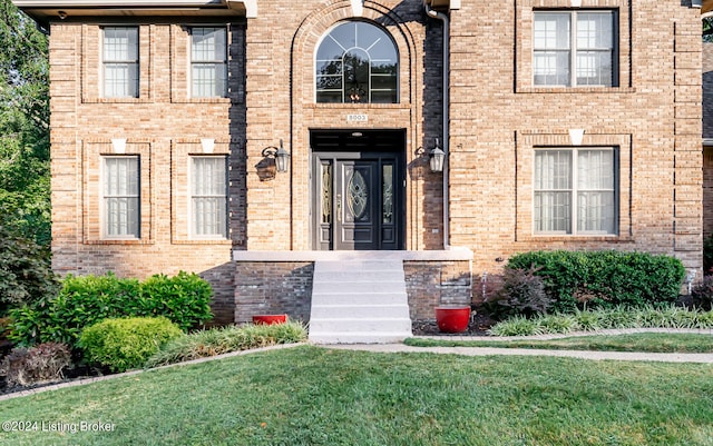 doorway to property with a lawn