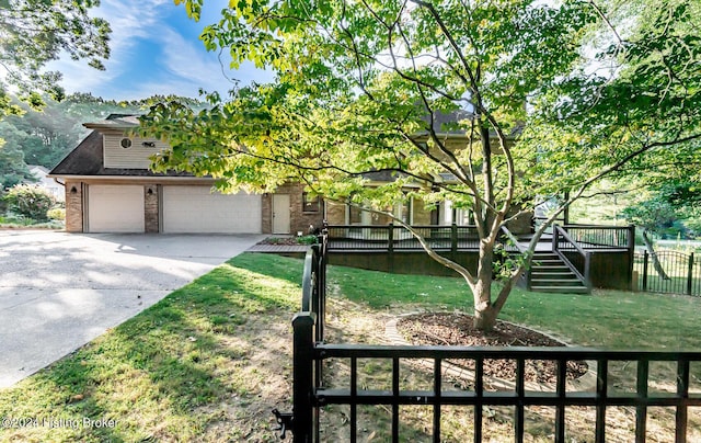 view of front of home with brick siding, a front yard, fence, driveway, and stairs