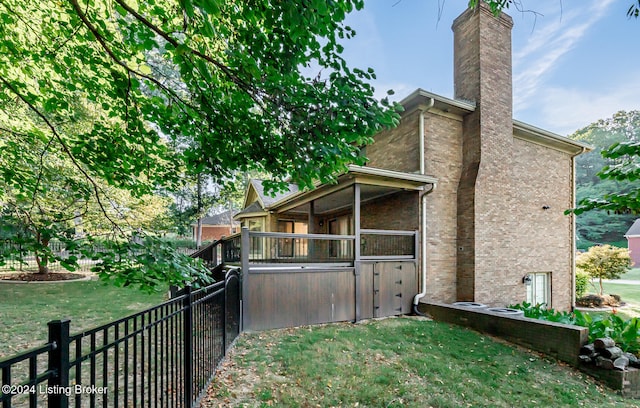 view of side of property featuring a wooden deck and a yard