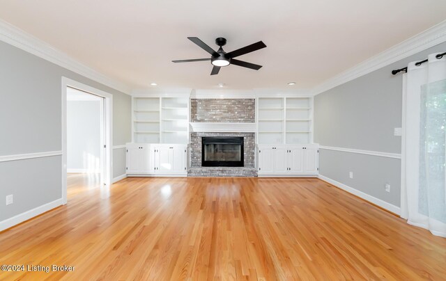 unfurnished living room featuring crown molding, light wood-type flooring, and a fireplace