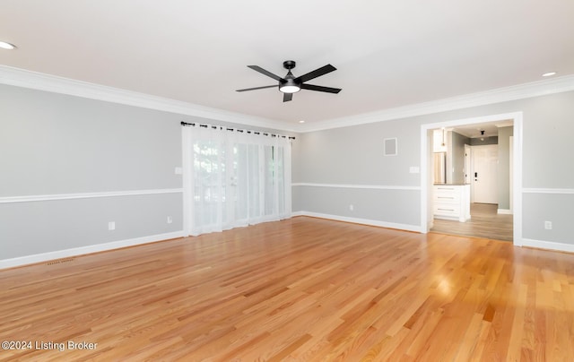 empty room with ceiling fan, visible vents, baseboards, light wood-type flooring, and crown molding