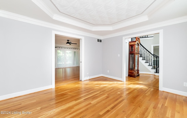 spare room featuring crown molding, hardwood / wood-style flooring, a tray ceiling, and ceiling fan