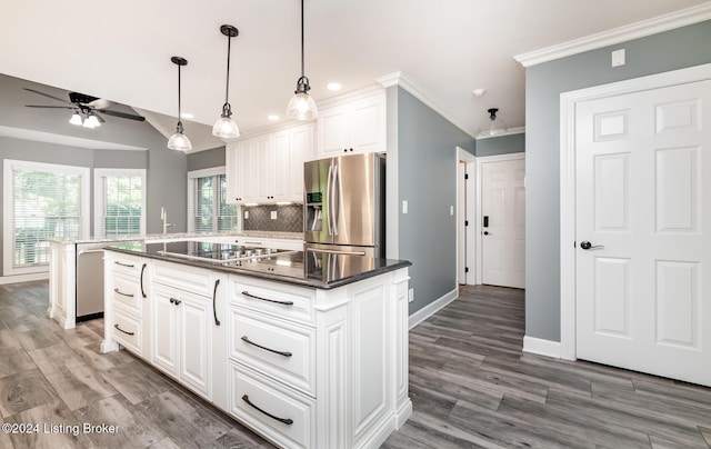 kitchen with decorative backsplash, stainless steel appliances, hardwood / wood-style floors, a center island, and white cabinets