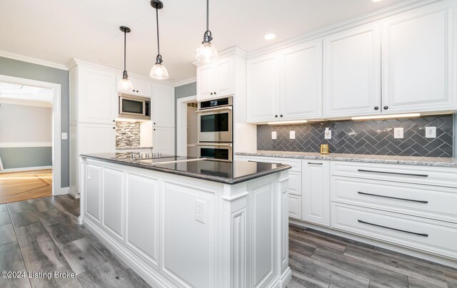 kitchen featuring appliances with stainless steel finishes, decorative light fixtures, white cabinets, dark wood-type flooring, and decorative backsplash