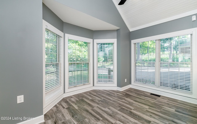 spare room featuring hardwood / wood-style flooring, ceiling fan, vaulted ceiling, and a wealth of natural light