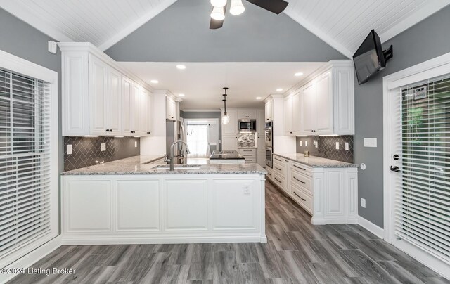 kitchen with white cabinetry, appliances with stainless steel finishes, kitchen peninsula, and hanging light fixtures