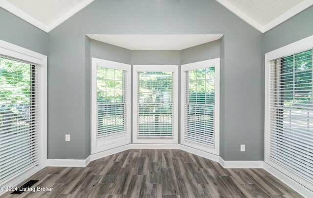 unfurnished room with dark wood-type flooring and vaulted ceiling