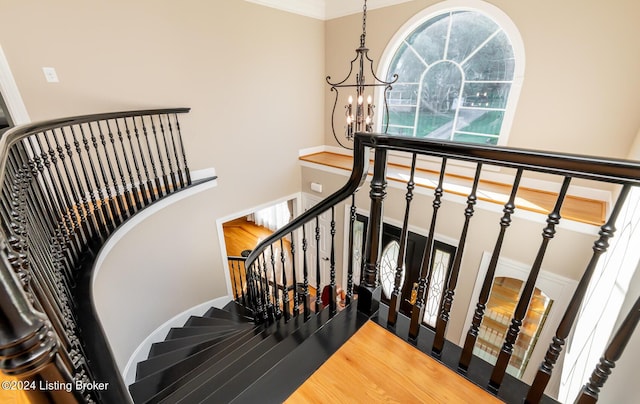 stairs featuring a notable chandelier