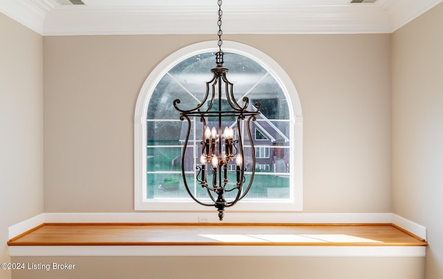 interior details featuring crown molding and a chandelier