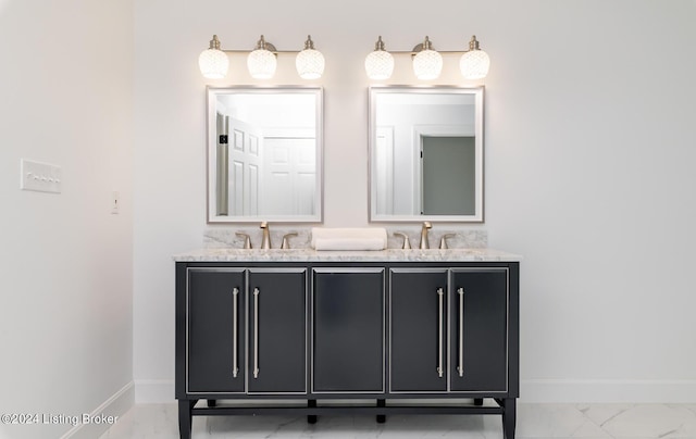 full bathroom with marble finish floor, a sink, baseboards, and double vanity