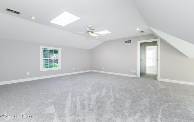 bonus room featuring a wealth of natural light, vaulted ceiling with skylight, carpet floors, and ceiling fan