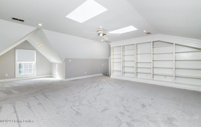 additional living space with vaulted ceiling, carpet floors, and built in shelves