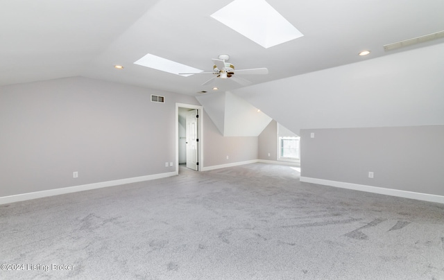 bonus room with vaulted ceiling with skylight, light carpet, and ceiling fan