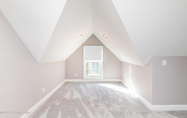 bonus room with lofted ceiling, baseboards, and light colored carpet