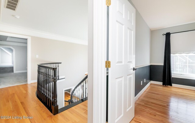 corridor featuring ornamental molding and hardwood / wood-style floors