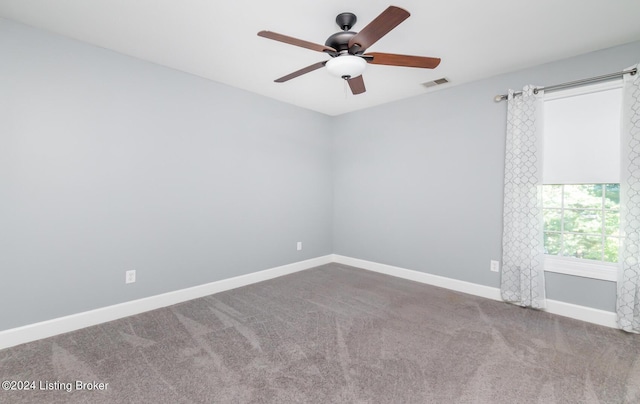 carpeted empty room with visible vents, ceiling fan, and baseboards