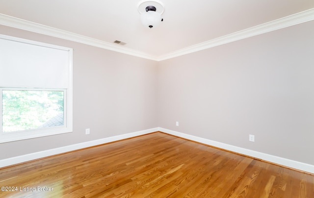 empty room with crown molding and hardwood / wood-style floors