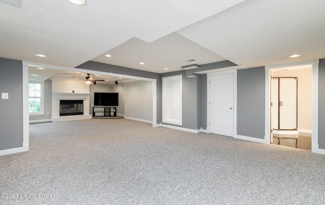 unfurnished living room featuring light colored carpet and ceiling fan