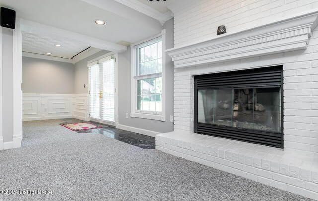 interior space with carpet, crown molding, a fireplace, and a healthy amount of sunlight