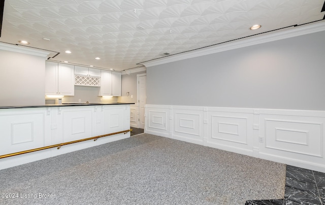 kitchen featuring crown molding, white cabinets, and dark carpet