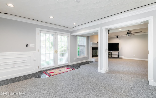 doorway to outside featuring dark colored carpet, ornamental molding, and ceiling fan