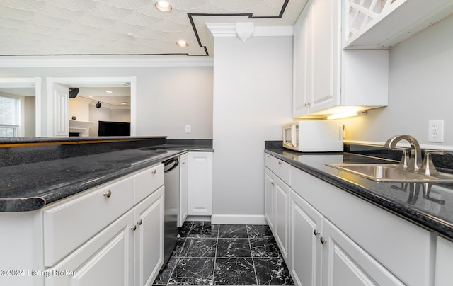 kitchen featuring marble finish floor, crown molding, white microwave, white cabinetry, and a sink