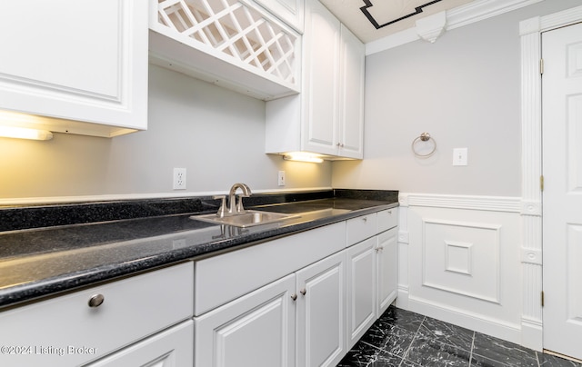 kitchen featuring ornamental molding, sink, and white cabinets