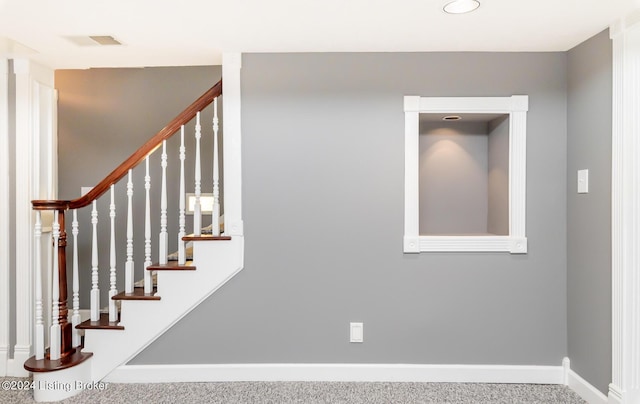 stairway with carpet floors, visible vents, and baseboards