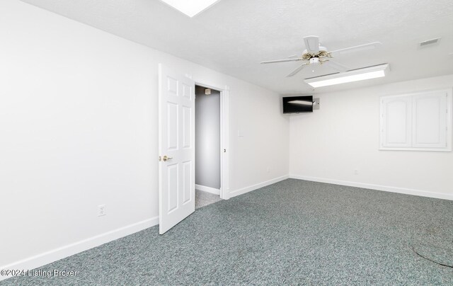 basement featuring ceiling fan, carpet, and a textured ceiling