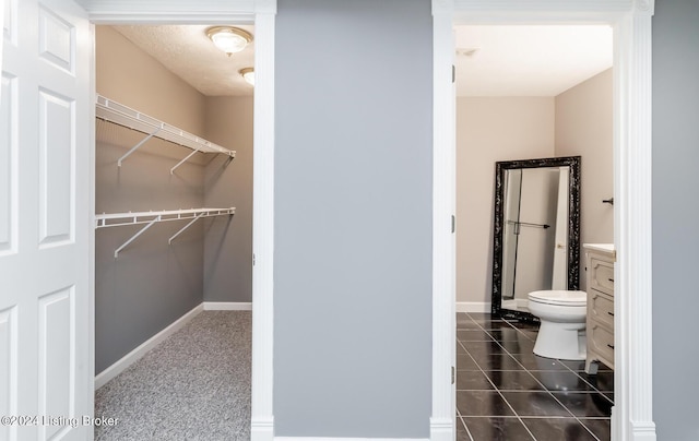 bathroom with toilet, tile patterned floors, vanity, and baseboards