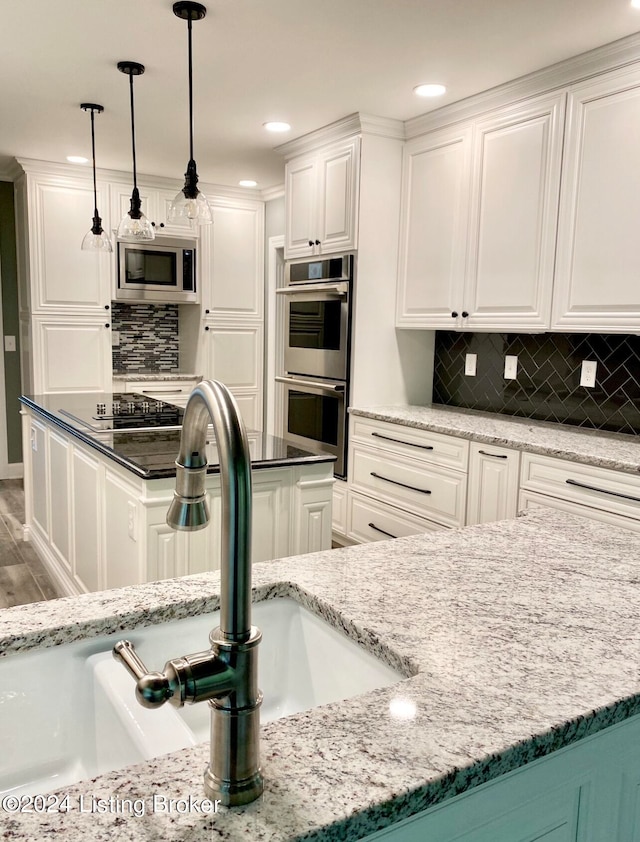 kitchen featuring tasteful backsplash, stainless steel appliances, sink, and dark stone counters