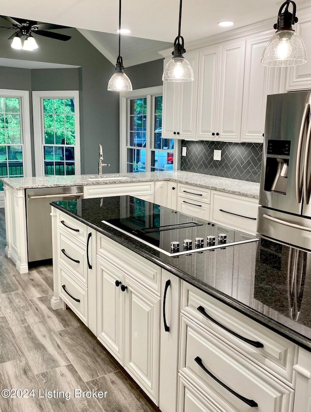 kitchen featuring appliances with stainless steel finishes, white cabinetry, and dark stone countertops