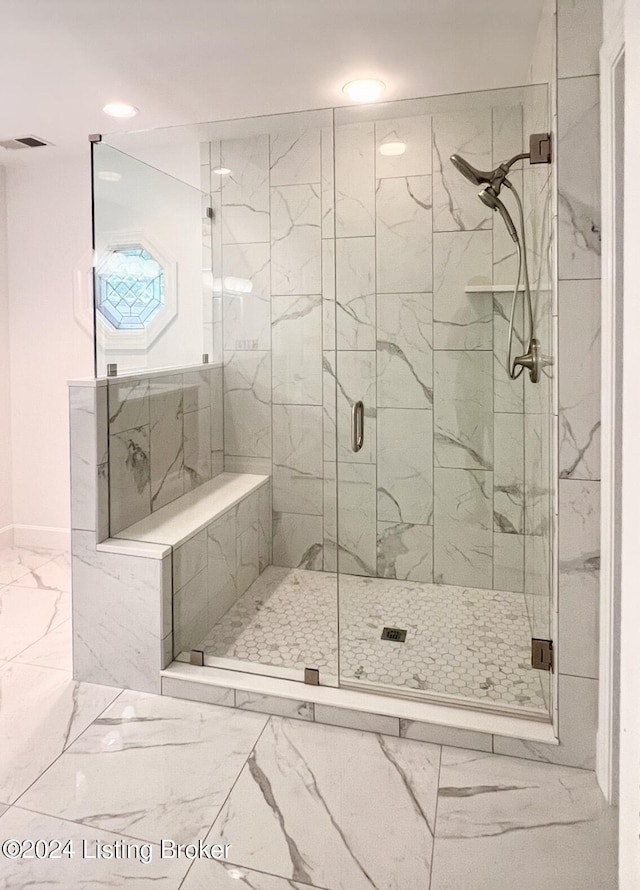 bathroom featuring marble finish floor, a marble finish shower, and visible vents