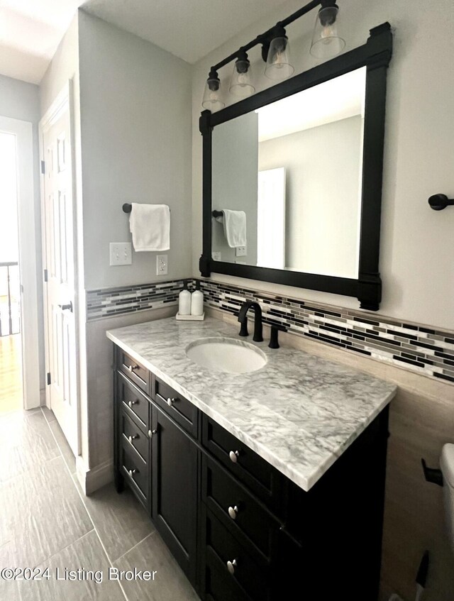 bathroom with vanity and tile walls