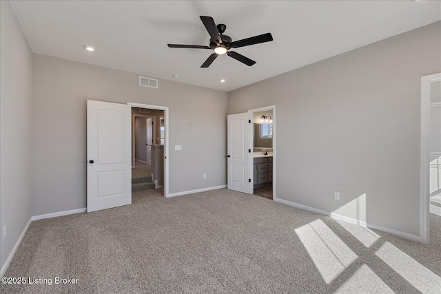 unfurnished bedroom featuring sink, ensuite bathroom, ceiling fan, and carpet flooring