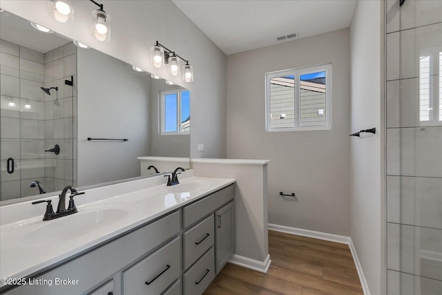 bathroom featuring a shower with door, vanity, and hardwood / wood-style flooring