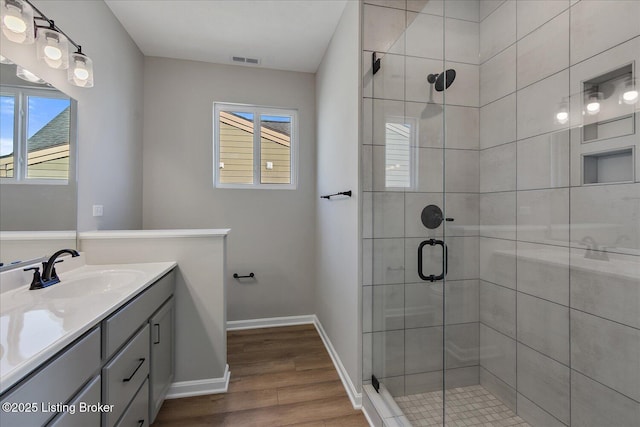 bathroom featuring vanity, hardwood / wood-style floors, and a shower with door