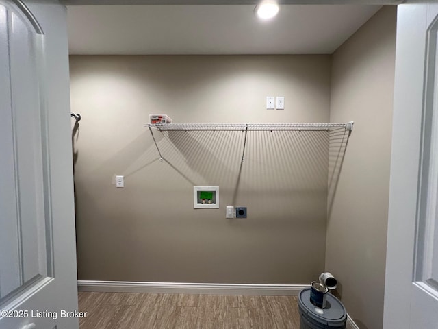 clothes washing area featuring electric dryer hookup, washer hookup, wood finished floors, and baseboards