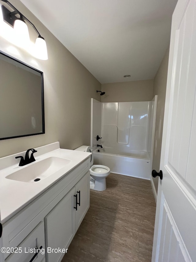 bathroom featuring toilet, shower / bathtub combination, wood finished floors, and vanity
