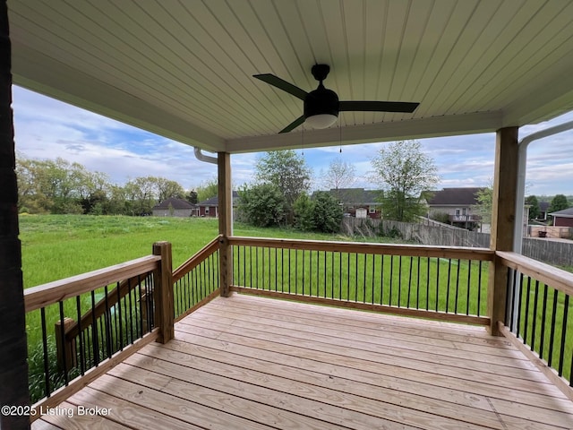 wooden terrace with fence, ceiling fan, and a yard