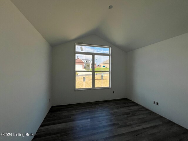 additional living space featuring lofted ceiling and dark hardwood / wood-style floors