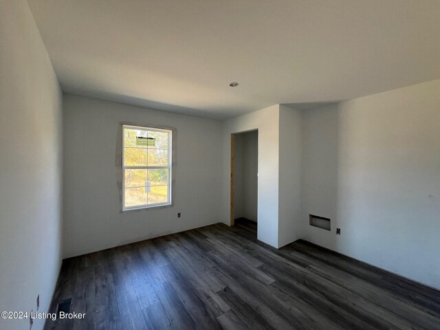 unfurnished room with dark wood-type flooring