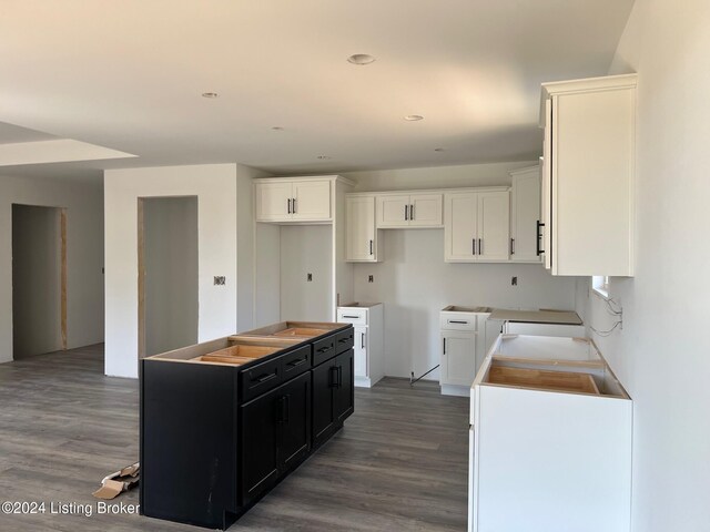 kitchen with white cabinetry, hardwood / wood-style floors, and a kitchen island