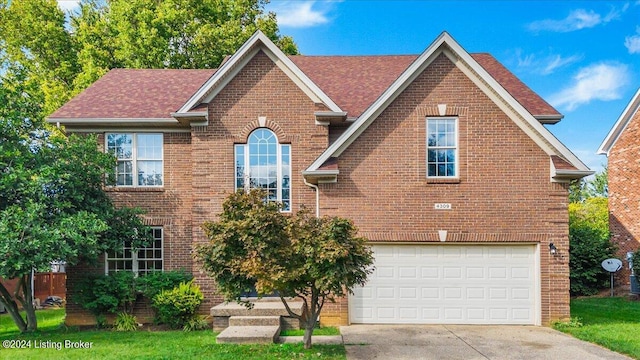 traditional home with a garage, concrete driveway, and brick siding