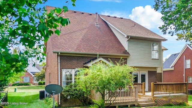 back of property featuring roof with shingles, central AC unit, a deck, and brick siding