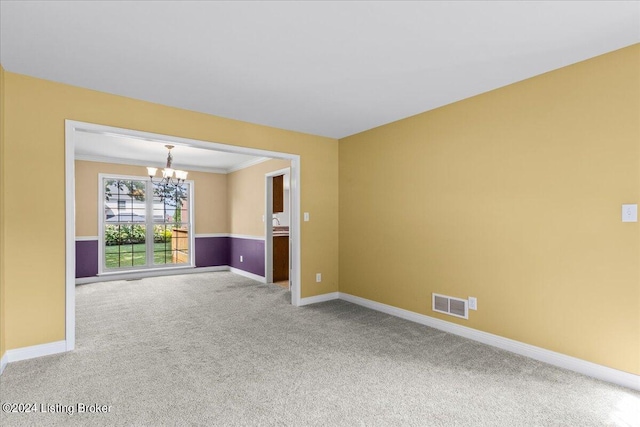 empty room with baseboards, visible vents, ornamental molding, an inviting chandelier, and carpet flooring