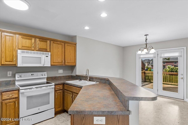 kitchen with white appliances, dark countertops, a peninsula, hanging light fixtures, and a sink