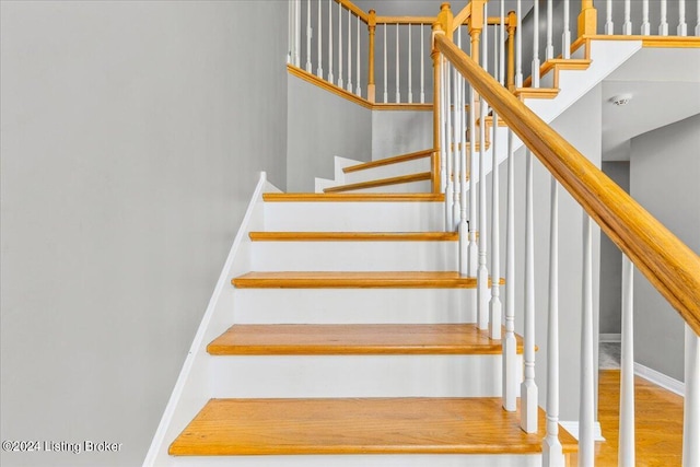 stairs with wood finished floors and baseboards